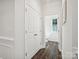 Hallway view of powder room with wood floors and adjacent closet for storage at 1008 Millbridge Pkwy, Waxhaw, NC 28173