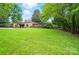 Expansive backyard with lush green lawn, mature trees, and a view of the house at 1042 Heather Glen Dr, Matthews, NC 28104