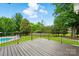 Large backyard with mature trees, iron fence, pool, and lush landscaping at 1042 Heather Glen Dr, Matthews, NC 28104