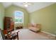 Bright bedroom features vaulted ceiling, large window and classic chair with crib at 1042 Heather Glen Dr, Matthews, NC 28104