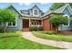 Charming home featuring blue siding, brick accents, a manicured lawn, and mature landscaping at 1042 Heather Glen Dr, Matthews, NC 28104
