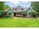 Charming two-story home with blue siding, brick accents, and a well-manicured lawn at 1042 Heather Glen Dr, Matthews, NC 28104