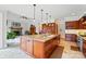 Kitchen island featuring a double sink and seating overlooks a large living space with fireplace at 1042 Heather Glen Dr, Matthews, NC 28104