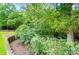 Nicely landscaped yard with mature trees, shrubs, and retaining wall, offering privacy and serenity at 1042 Heather Glen Dr, Matthews, NC 28104