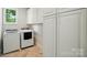 Well-equipped laundry room with modern washer and dryer, and ample storage space at 1042 Heather Glen Dr, Matthews, NC 28104