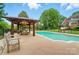 Inviting pool area with a gazebo, seating, and well-manicured landscaping at 1042 Heather Glen Dr, Matthews, NC 28104