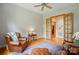 Bright sitting room with hardwood floors, leather armchair, and access to a study through french doors at 1042 Heather Glen Dr, Matthews, NC 28104