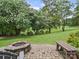 Landscaped backyard with a stone fire pit and seating area at 106 Boyter Ct, Cramerton, NC 28032