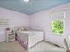 Bright bedroom features a light purple color scheme, a white bedframe, and a window offering a view of the outdoors at 106 Boyter Ct, Cramerton, NC 28032