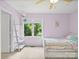 Charming bedroom with lilac walls, ceiling fan, and white furnishings, offering a peaceful and stylish retreat at 106 Boyter Ct, Cramerton, NC 28032