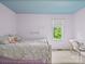 Bright bedroom features a light purple color scheme, a white bedframe, and a window offering a view of the outdoors at 106 Boyter Ct, Cramerton, NC 28032