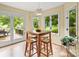 Sunlit breakfast nook with a rustic wooden table, bar stools, and backyard view at 106 Boyter Ct, Cramerton, NC 28032