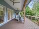 Covered deck with outdoor seating and a view of the lush greenery at 106 Boyter Ct, Cramerton, NC 28032
