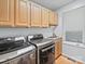 Well-equipped laundry room featuring a modern washer and dryer, storage cabinets, and a convenient sink at 106 Boyter Ct, Cramerton, NC 28032