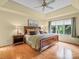 Comfortable main bedroom featuring a tray ceiling, a large window and wood flooring at 106 Boyter Ct, Cramerton, NC 28032