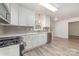 Modern kitchen featuring white cabinets, stainless steel appliances, subway tile backsplash and light wood flooring at 10606 Danesway Ln, Cornelius, NC 28031
