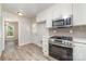 Modern kitchen features stainless steel appliances, white cabinets, and light grey backsplash at 10606 Danesway Ln, Cornelius, NC 28031