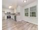 Modern kitchen featuring white cabinets, stainless steel appliances, gray tile backsplash and light wood flooring at 10606 Danesway Ln, Cornelius, NC 28031