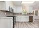 Modern kitchen showcasing white cabinets, stainless steel appliances, subway tile backsplash and light wood flooring at 10606 Danesway Ln, Cornelius, NC 28031
