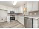 Bright modern kitchen featuring stainless steel appliances, white cabinets, gray tile backsplash, and light wood flooring at 10606 Danesway Ln, Cornelius, NC 28031