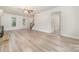 Bright living room showcasing a brick fireplace, light wood flooring, staircase to second floor and natural light at 10606 Danesway Ln, Cornelius, NC 28031