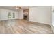 Bright living room showcasing a brick fireplace, light wood flooring, and access to the backyard through French doors at 10606 Danesway Ln, Cornelius, NC 28031
