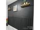 Stylish bathroom featuring black accent wall with decorative shelves, wood paneling, and modern design at 12320 Verdant Ct, Charlotte, NC 28273
