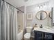 Clean bathroom featuring modern vanity, a tub with shower, and stylish fixtures and accessories at 12320 Verdant Ct, Charlotte, NC 28273