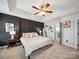 Bedroom featuring a ceiling fan, a large bed, and a stylish accent wall at 12320 Verdant Ct, Charlotte, NC 28273
