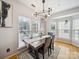 Bright dining area featuring a modern light fixture, wooden floors, and large windows at 12320 Verdant Ct, Charlotte, NC 28273