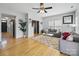 Bright living room featuring hardwood floors, a ceiling fan, and gray sofas at 12320 Verdant Ct, Charlotte, NC 28273