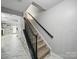 Inviting staircase with neutral walls and modern railing, creating an open and airy transition between floors at 12320 Verdant Ct, Charlotte, NC 28273