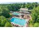 Stunning aerial view of a large community pool, clubhouse, playground, and lush green landscaping at 1241 Brough Hall Dr, Waxhaw, NC 28173