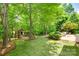 Secluded backyard featuring a lush lawn, mature trees, a play set, and a patio with outdoor furniture at 1241 Brough Hall Dr, Waxhaw, NC 28173