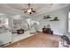 Open-concept living room with hardwood floors and neutral decor, seamlessly connecting to other living spaces at 1241 Brough Hall Dr, Waxhaw, NC 28173