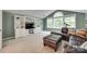 Living room with custom built-ins, large windows, and comfortable leather seating at 1241 Brough Hall Dr, Waxhaw, NC 28173