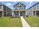 Charming two-story home with stone accents, gray shutters, well-maintained lawn and walkway at 125 Cedar Knoll Cir, Pineville, NC 28134