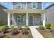 Inviting front porch with stone accents, gray door, and landscaped garden at 125 Cedar Knoll Cir, Pineville, NC 28134