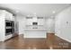 Modern kitchen with stainless steel appliances, white cabinets, and a center island with sink at 125 Cedar Knoll Cir, Pineville, NC 28134