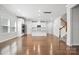 Open-concept living space with hardwood floors, seamlessly connecting living, dining, and kitchen areas at 125 Cedar Knoll Cir, Pineville, NC 28134