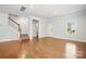 Open living room with hardwood floors and stairs features neutral walls and a large window at 125 Cedar Knoll Cir, Pineville, NC 28134