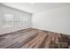 A bright bedroom featuring wood-look flooring and a large window providing lots of natural light at 125 Fosters Glen Pl, Mooresville, NC 28115