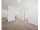 Upstairs hallway with neutral carpet, and a view of the stairs and multiple entryways to other rooms at 125 Fosters Glen Pl, Mooresville, NC 28115