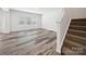 Open-concept living area with staircase, laminate flooring, and natural light from large windows at 125 Fosters Glen Pl, Mooresville, NC 28115