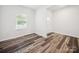 Clean, neutral room with wood-look floors, window, and white trim at 125 Fosters Glen Pl, Mooresville, NC 28115