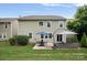 Spacious backyard featuring a patio with seating and dining area, plus well-maintained lawn and leafy trees at 131 Cherry Bark Dr, Mooresville, NC 28117