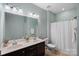 Well-lit bathroom with double vanity sinks, tiled floor, shower and toilet at 131 Cherry Bark Dr, Mooresville, NC 28117