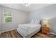 Simple bedroom featuring a queen-sized bed, nightstand, lamp, and a window with natural light at 131 Cherry Bark Dr, Mooresville, NC 28117