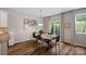Bright dining room with wood floors, stylish table, chairs, sliding glass door, and modern lighting at 131 Cherry Bark Dr, Mooresville, NC 28117