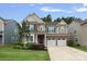 Charming two-story home with a manicured lawn, mature landscaping, and a two-car garage at 131 Cherry Bark Dr, Mooresville, NC 28117
